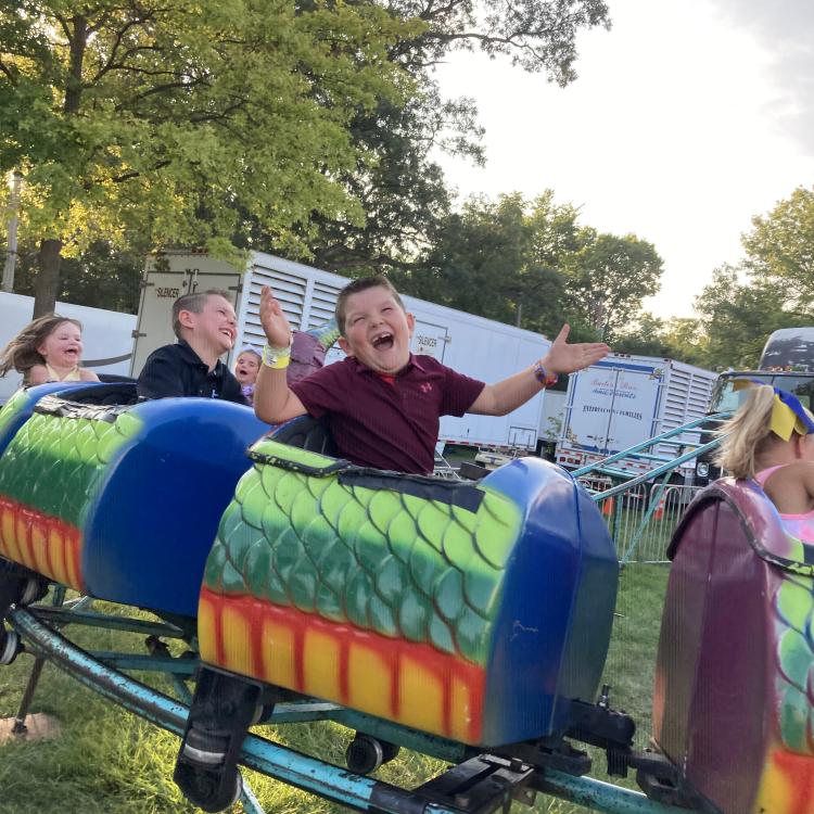 boy laughing on small roller coaster
