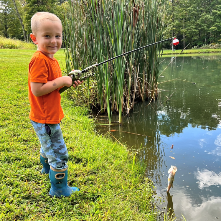 boy smiling holding a fish
