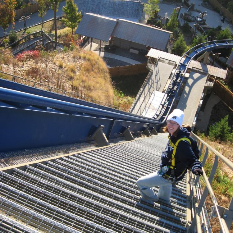 young woman climbing stairs along roller coaster track