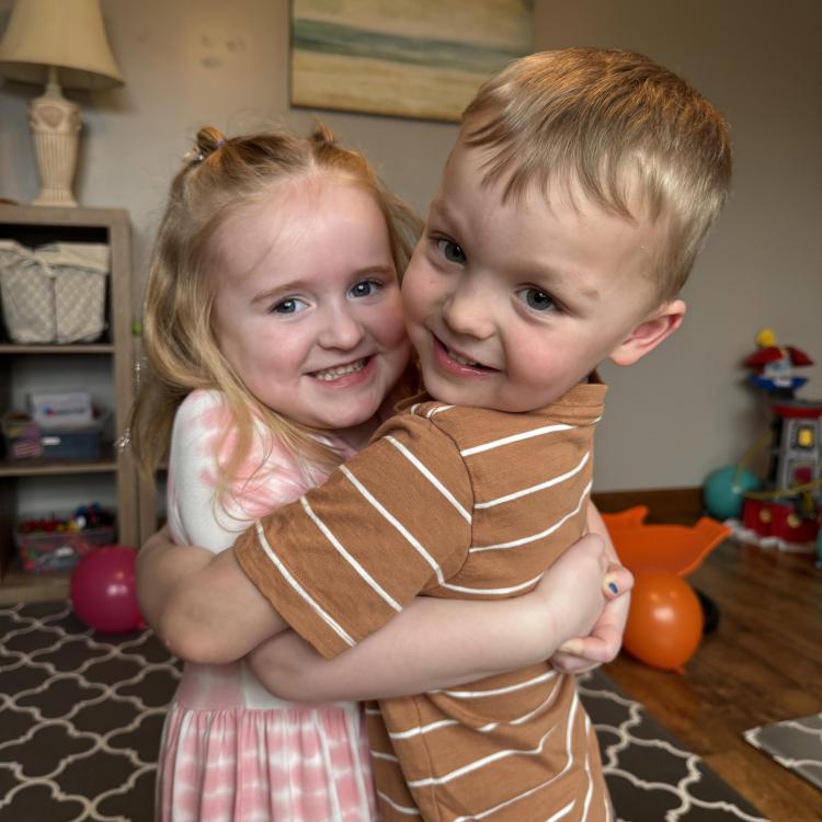little girl and little boy hugging