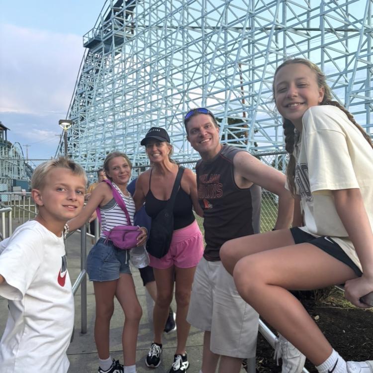 family in front of roller coaster