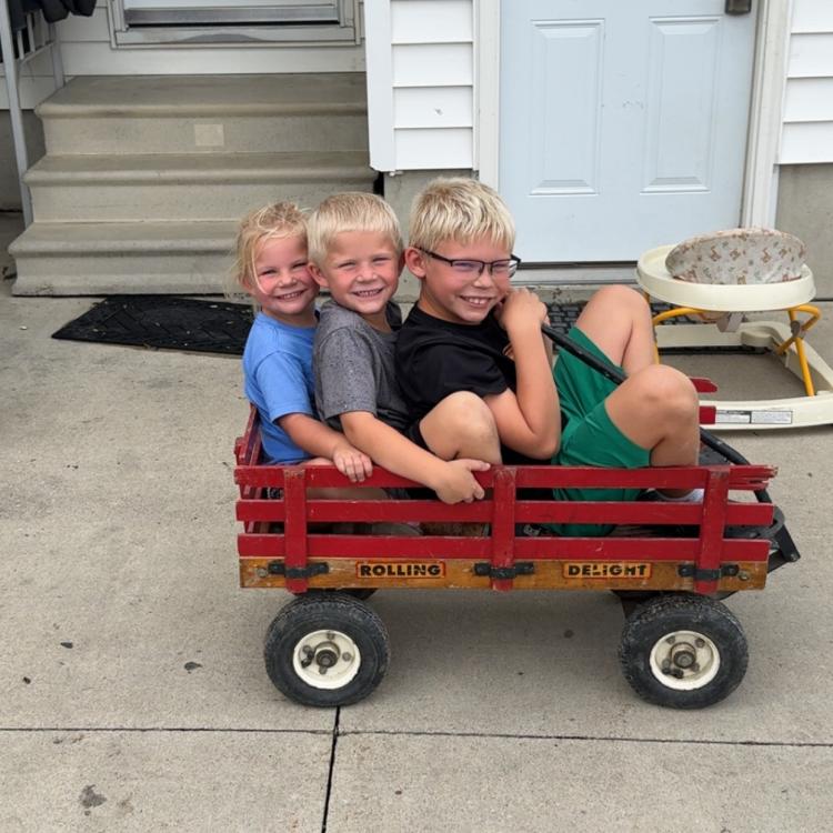 three kids in red wagon