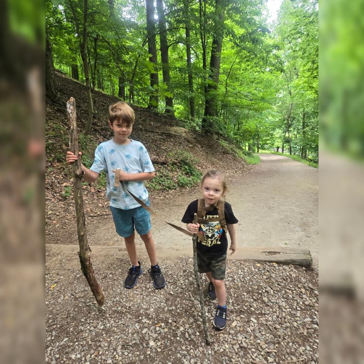 two children walking in the forest