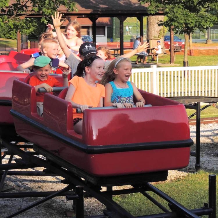children in red roller coaster car