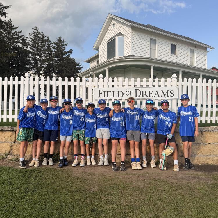 group of boys in front of fence and white house