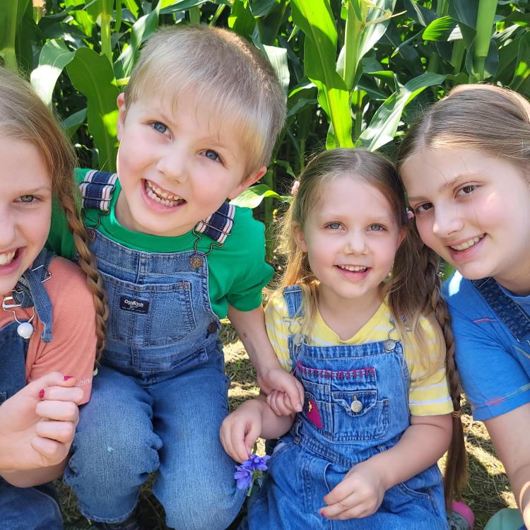 four smiling kids outside