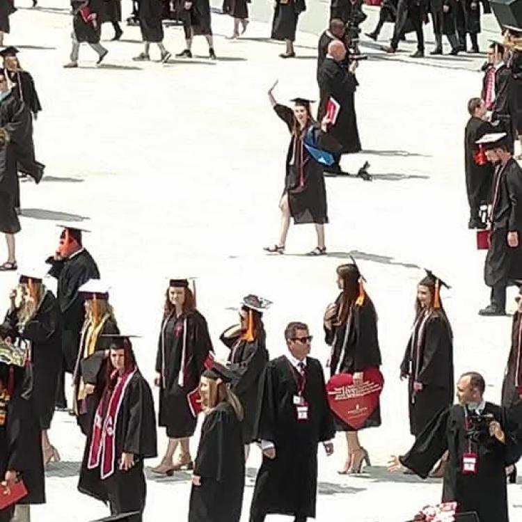 Young woman in crowd of graduates in black gowns