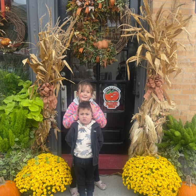 two children surrounded by autumn decorations
