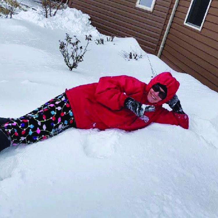 person in red jacket lying in the snow