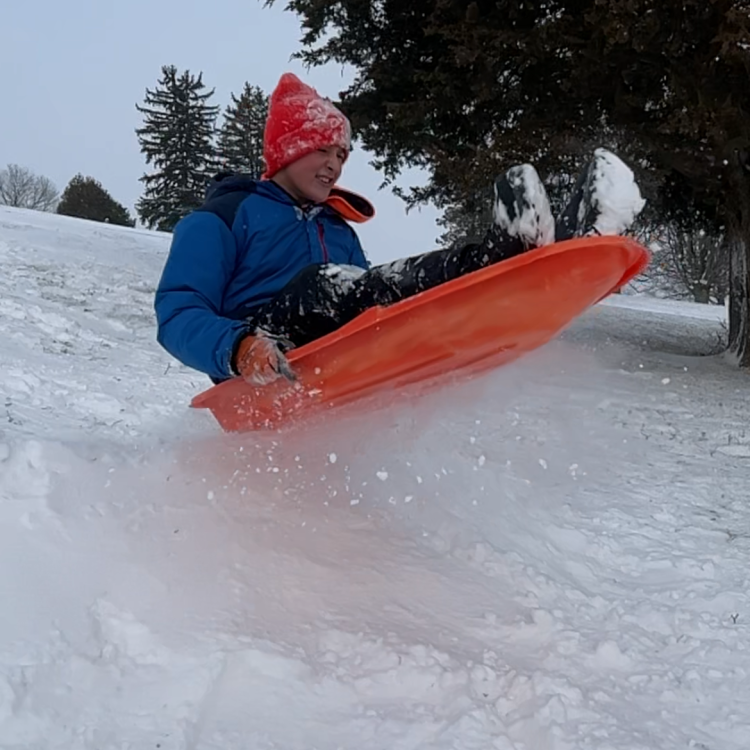 child flying on sled