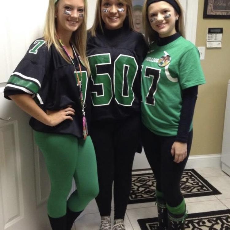 three girls standing with man looking through window behind