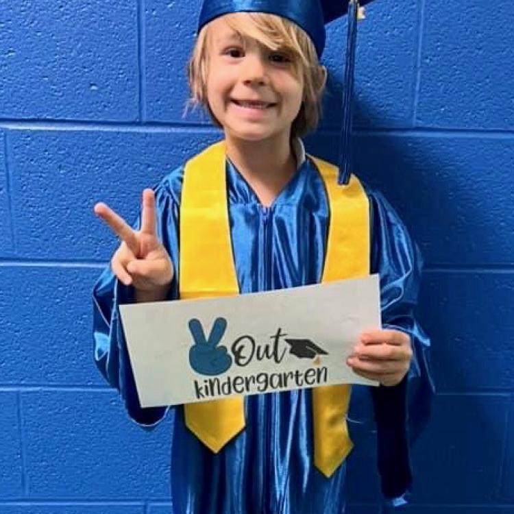 little boy in blue graduation cap and gown