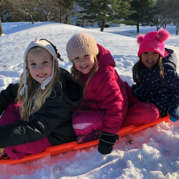 three kids on sled in snow