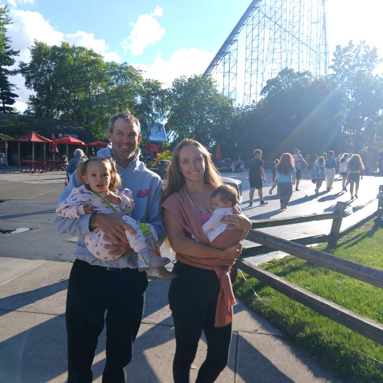 family standing in front of roller coaster