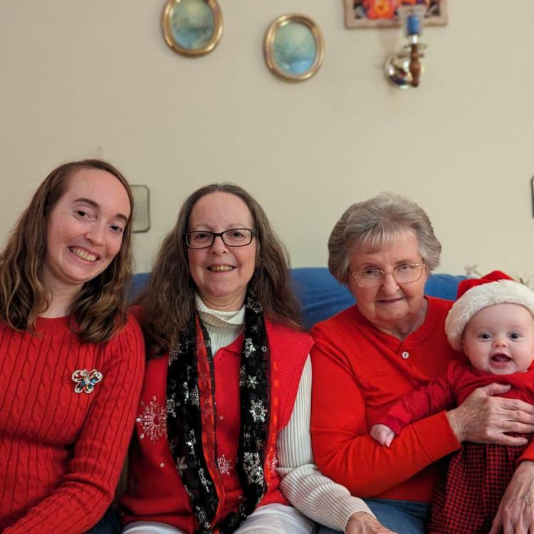 three women and a baby in a Santa hat