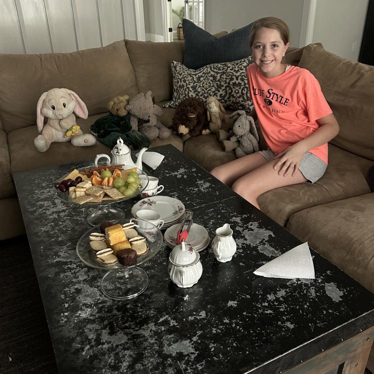 girl having tea party with stuffed animals