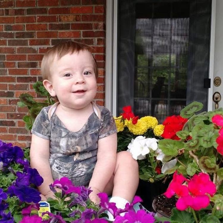 little boy by flowers