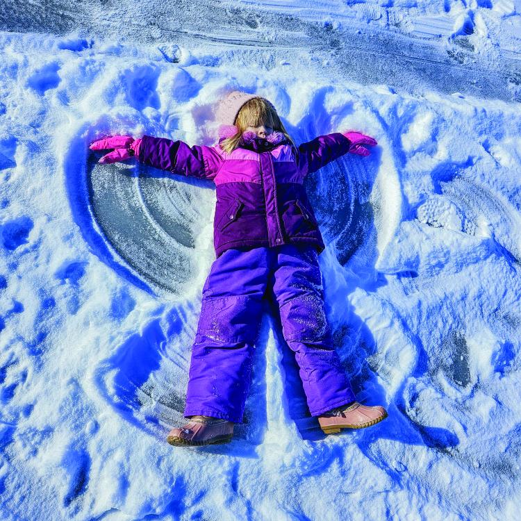 girl making snow angel