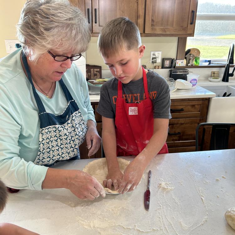 woman making pie crust with boy