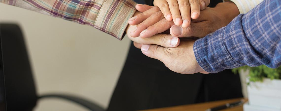 A team of people putting hands together