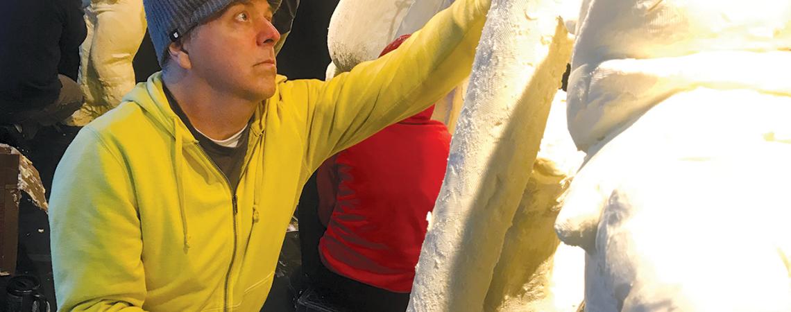 A sculptor working on their butter sculpture.