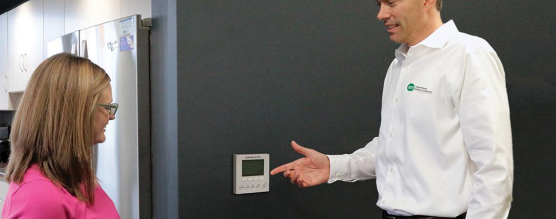 Michael Wilson, an energy advisor at Logan County Electric Cooperative, demonstrates a programmable thermostat.
