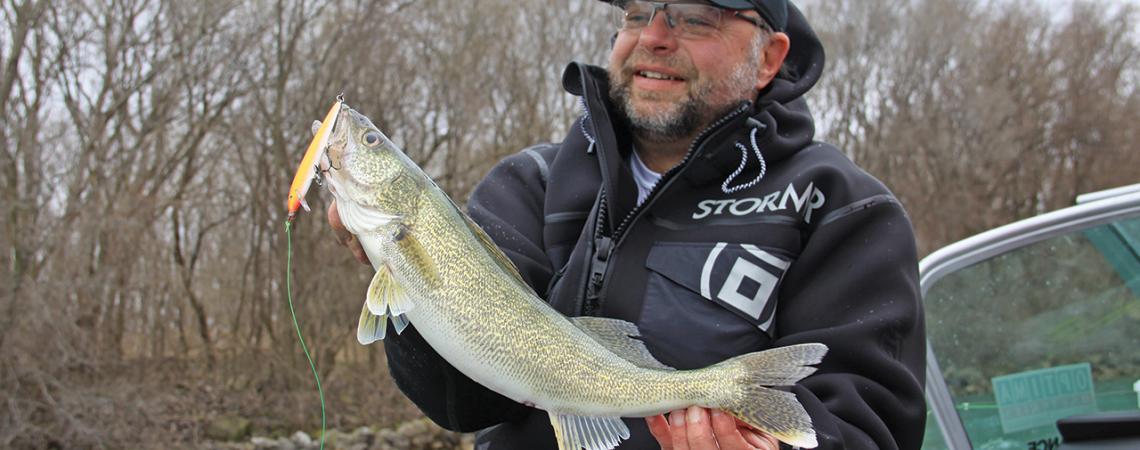 Mark Martin smiles and examines a huge walleye he caught.