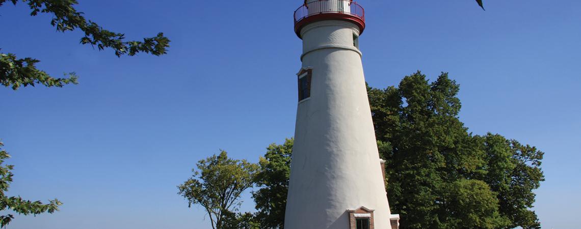 A photo of Marblehead Lighthouse surrounded by people and Lake Erie in the background