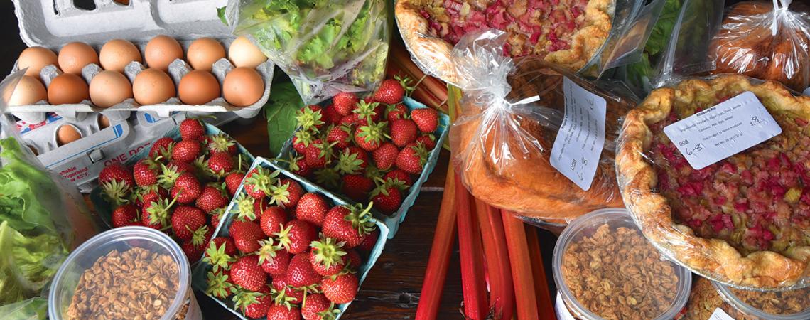 A picture of assorted foods, including strawberries, eggs, lettuce, bread, nuts, and pies.