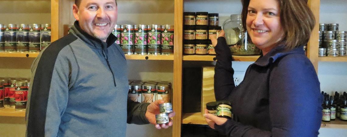 Dawn and Carson Combs pose for a figure alongside jars of products.