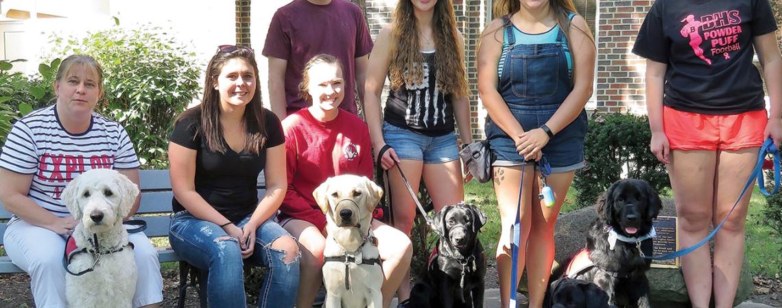 Polar Paws volunteers show off their trainees for the group’s founder, Matt Sutton.