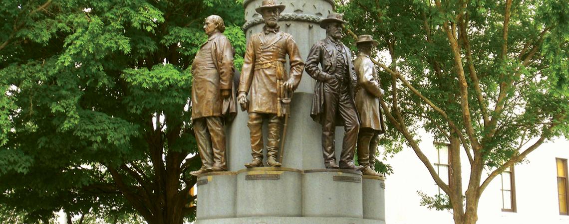 A monument featuring bronze statues of seven Ohioans and a Roman noblewoman.