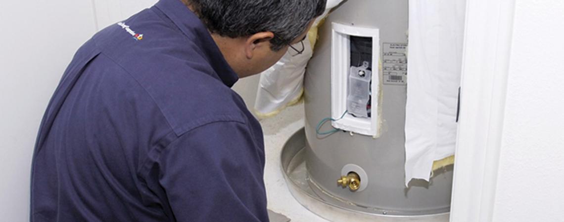 A man examines a water heater