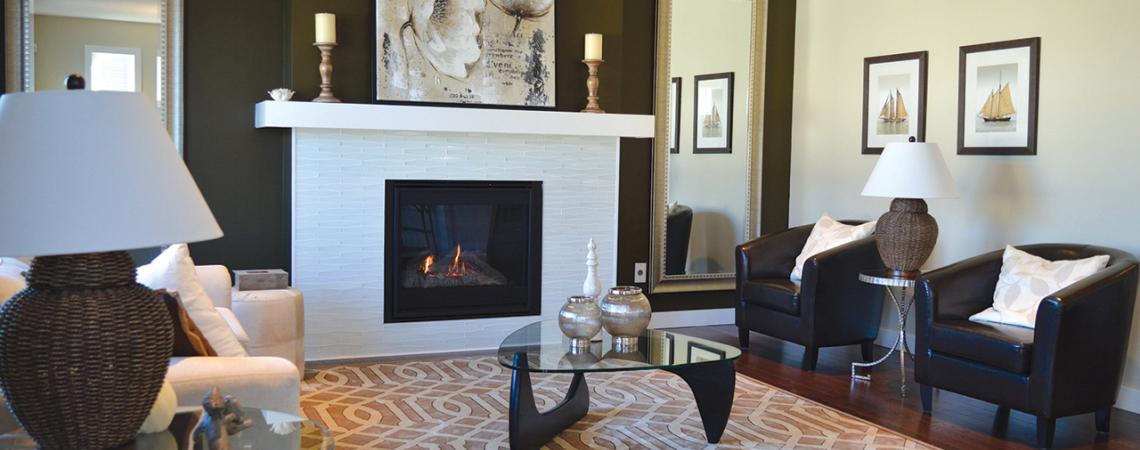 A living room including chairs, couches, tables, and a fireplace.