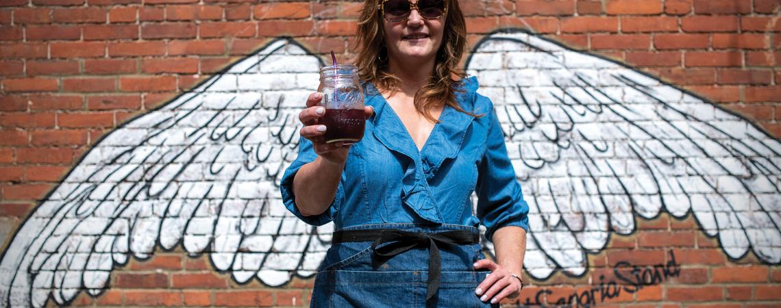 Dori Heck displays a glass of sangria at the Sangria Stand in Massillon.