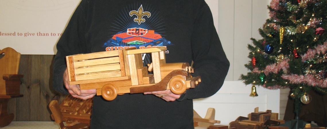 Judge Scott Phillips examining a wooden truck made by  Neal Pleiman of Osgood.