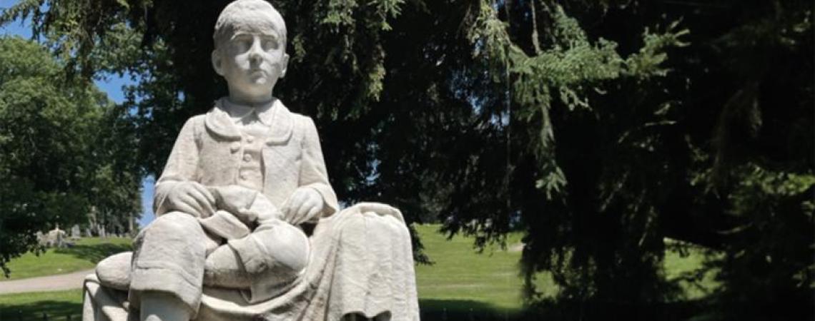 “Little Georgie” Blount’s Green Lawn grave inspires visitors to donate hats and scarves during cold weather.