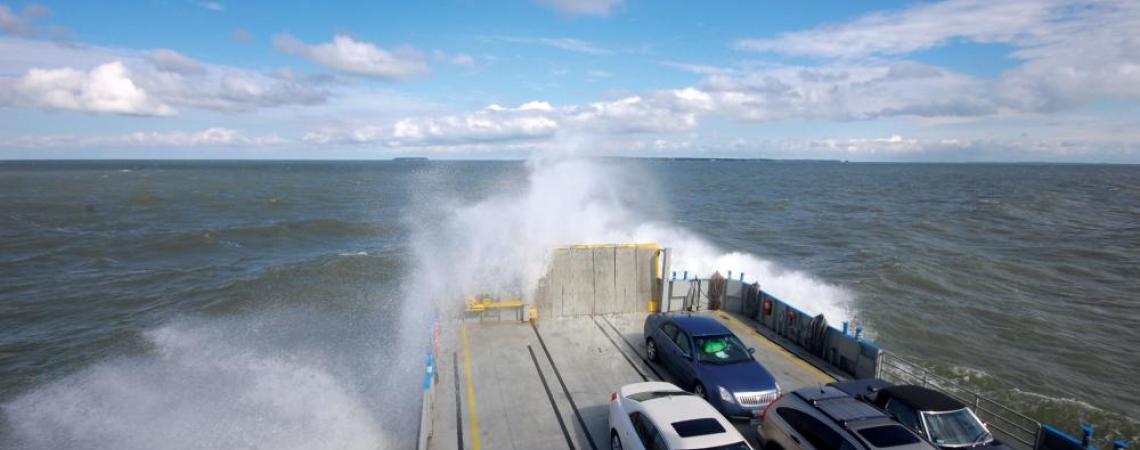 Vehicles parked on a ferry, being transported from one side of the lake to the other.