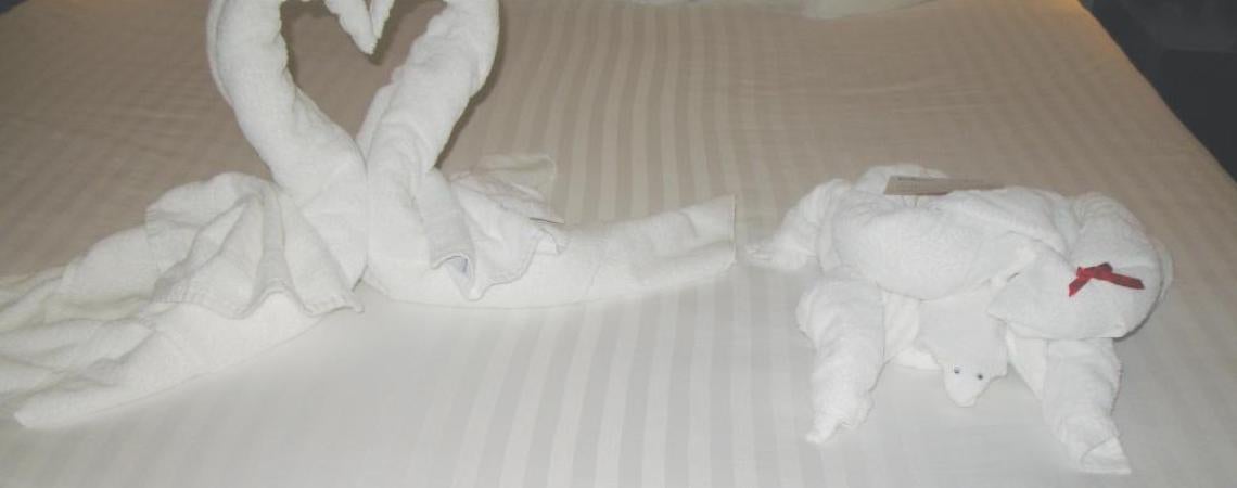 Animals made from towels displayed on a hotel bed