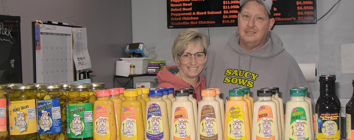 Scott and Denise Scherer posing in their market named Saucy Sows