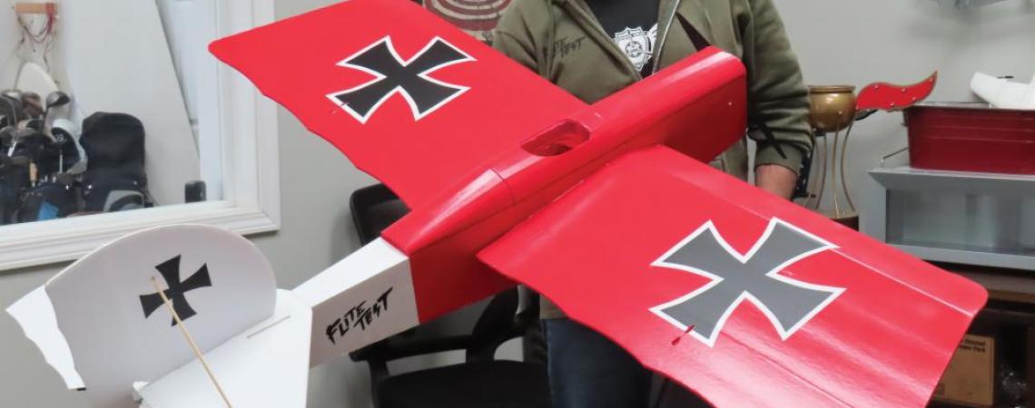 Josh Bixler holding a 3-D printed airplane