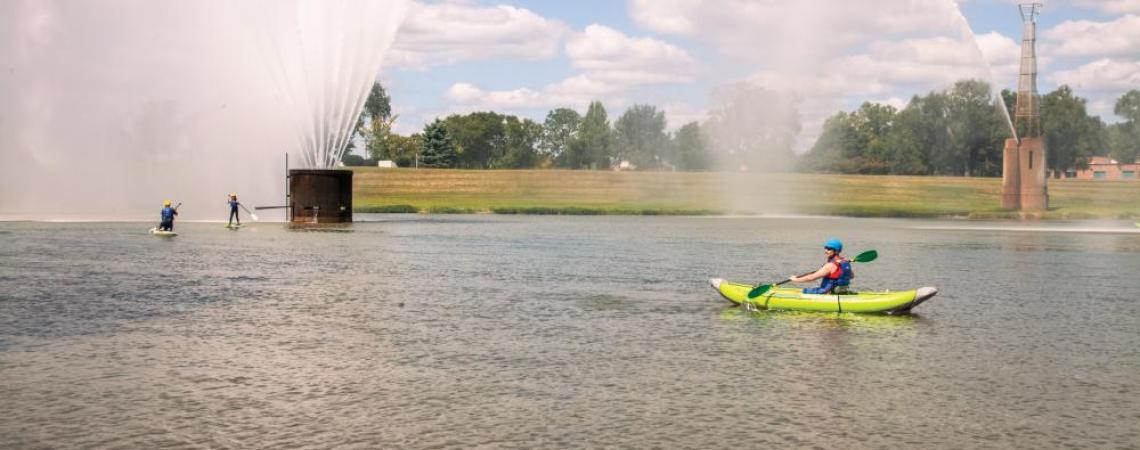People paddle boarding and kayaking on a river