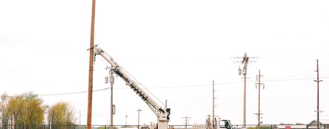 A group of lineworkers raising a nesting pole for a family of ospreys