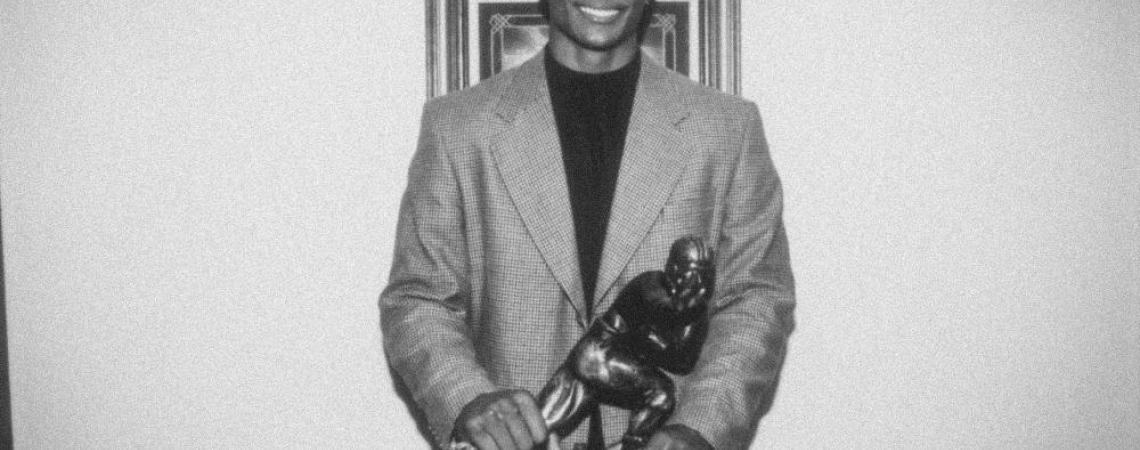Eddie George with a Heisman Trophy
