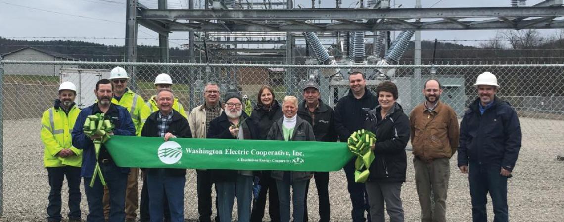 A group of people at an electric substation ribbon cutting