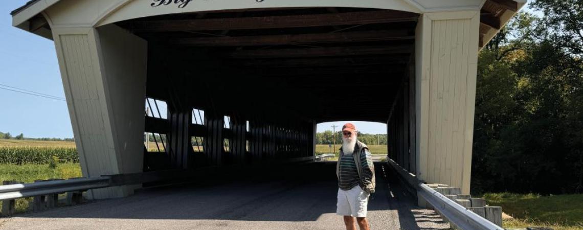 Steve Stolte posing with a covered bridge
