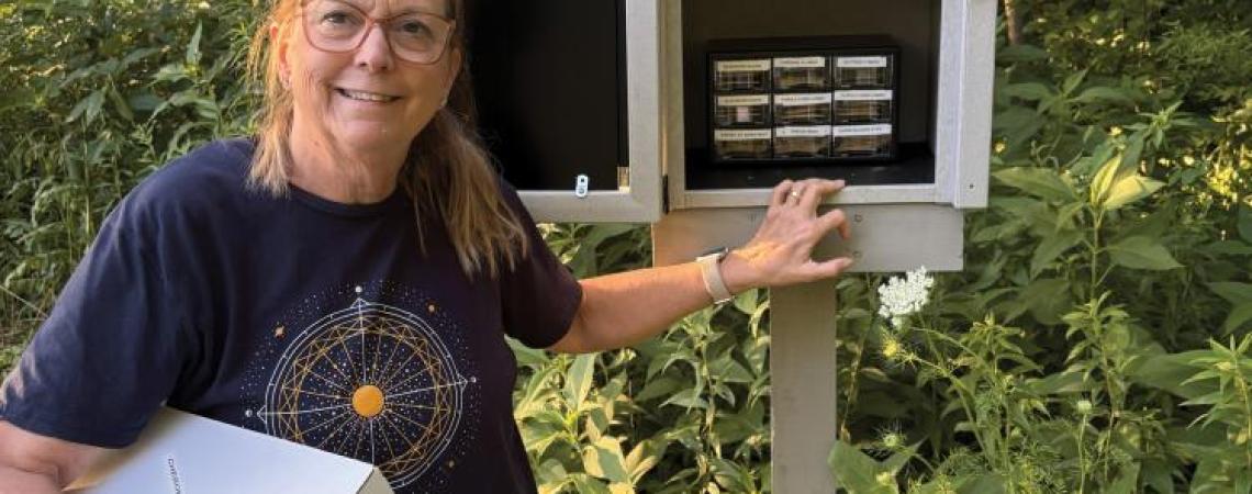 A woman standing with a community seed library