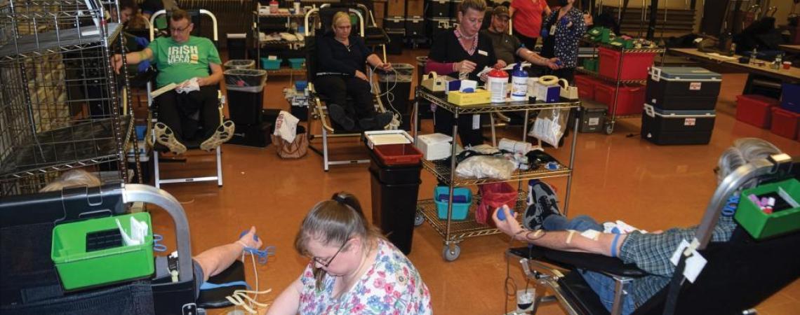 A group of people donating blood during a blood drive