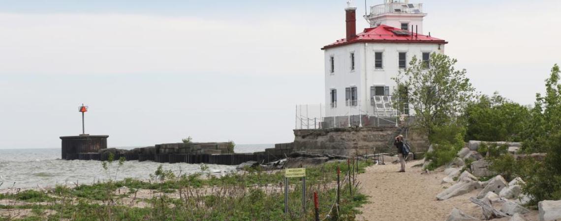 A person standing in front of a lighthouse