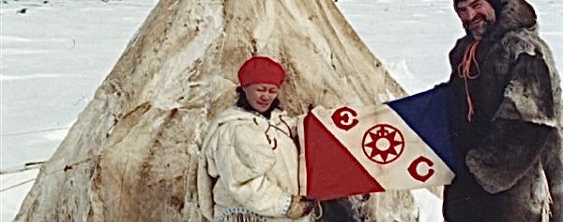 Two men posing in snow in front of a teepee